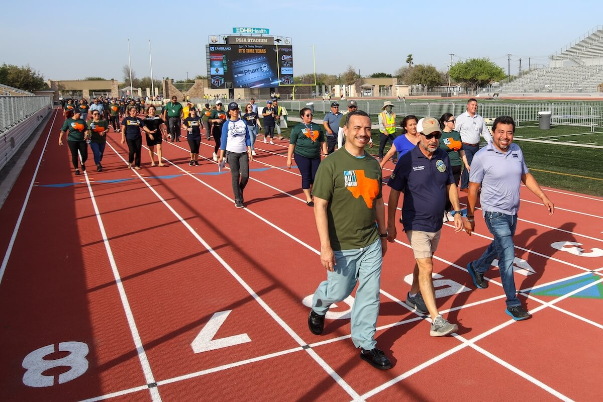 A large group of community members walking on a track