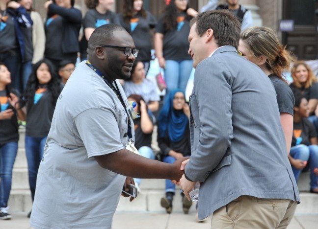 Man shaking hands with the founder of It's Time Texas at an outdoor rally in Austin, Texas