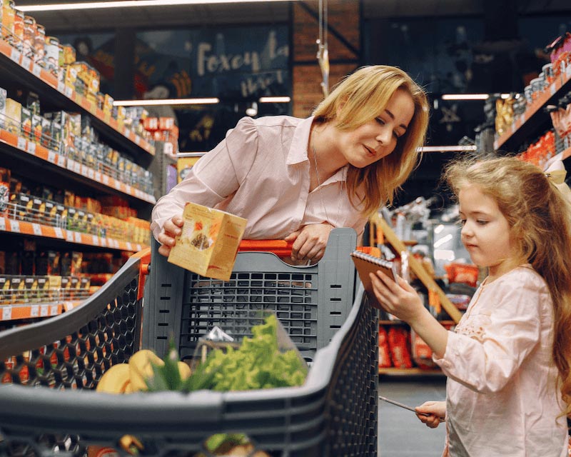 A woman shopping for groceries with her daughter