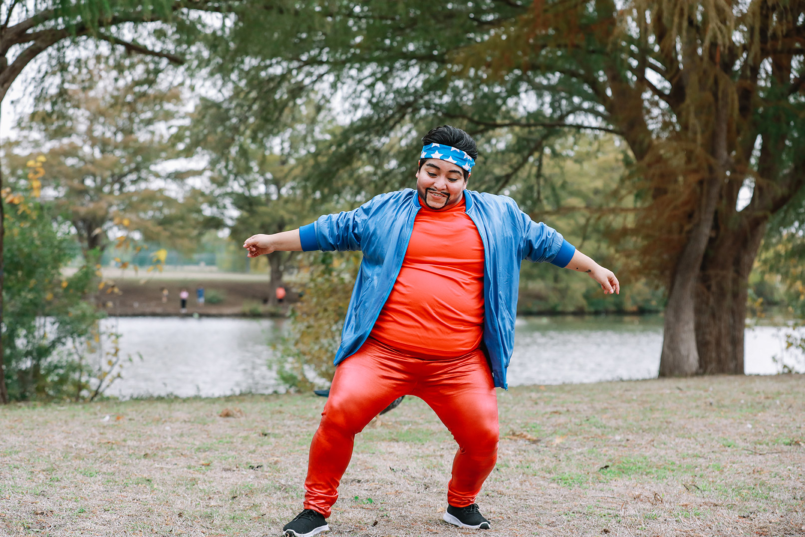 A young adult male dancing in a park